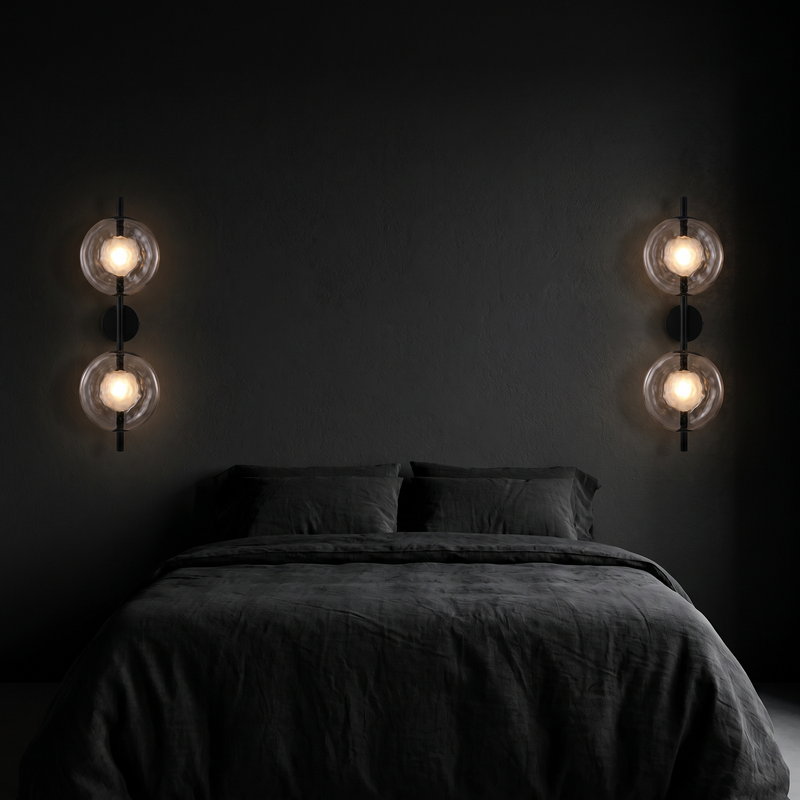 Double glass disc wall sconces, a pair mounted either side of a bed on a dark wall