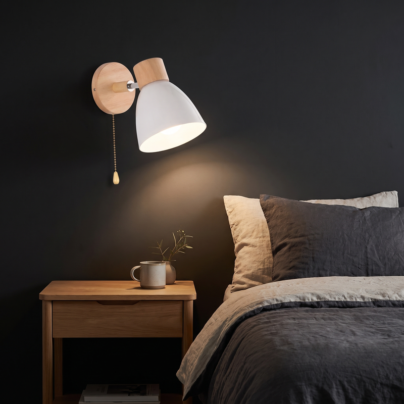 Nordic Wood Wall Sconce with Pull Chain in white beside a bed