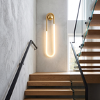 Gold wall sconce - Gold Loop LED Wall Sconce in the 29.5 in size on a staircase wall