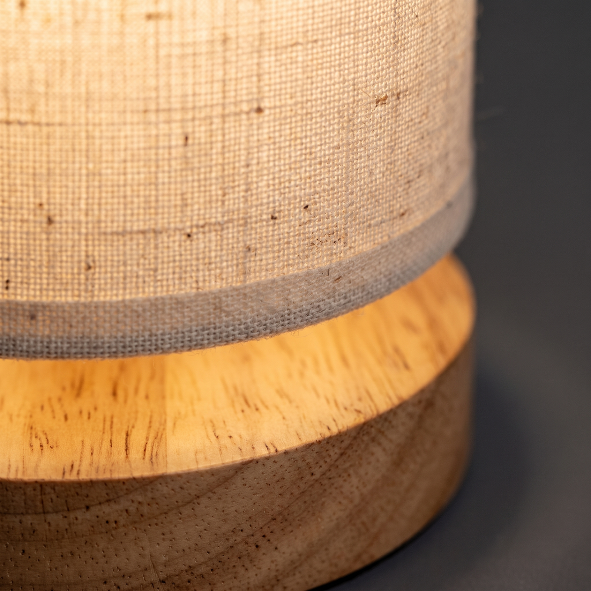 Close-up of the linen shade and wooden base of the Linen Shade Wooden Bedside Lamp
