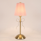 Pleated Bow Cordless Table Lamp in pink, switched on, on a plain background