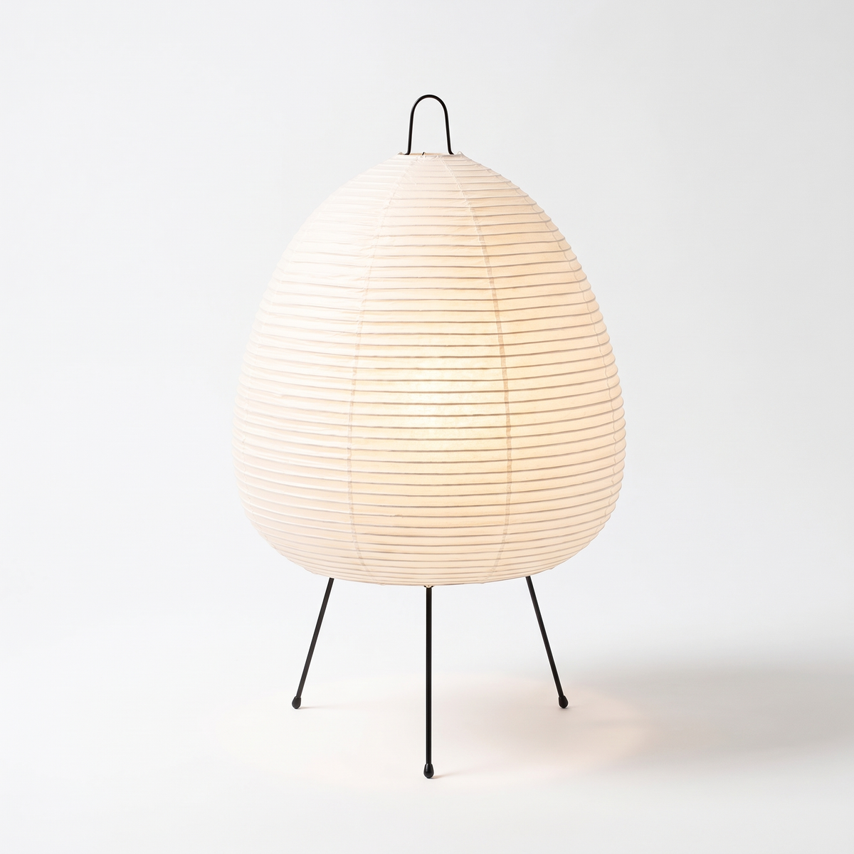 Table Lamp with Tall Rice Paper Egg Shade on Black Tripod Legs on white background
