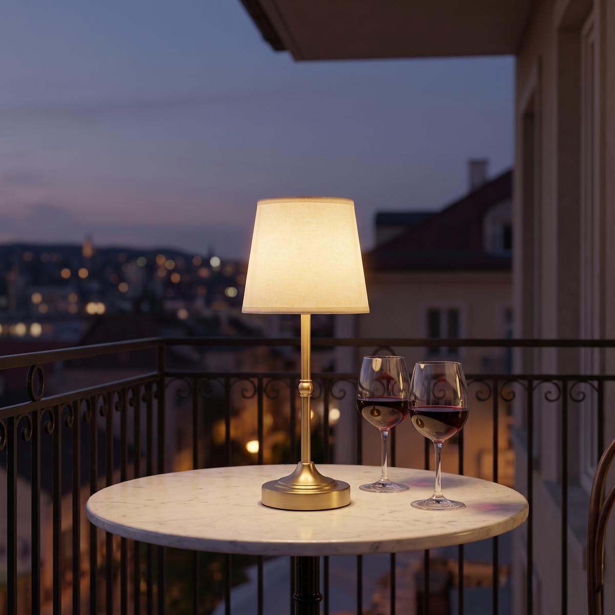 Dimmable Cordless Table Lamp in gold on a balcony table at dusk