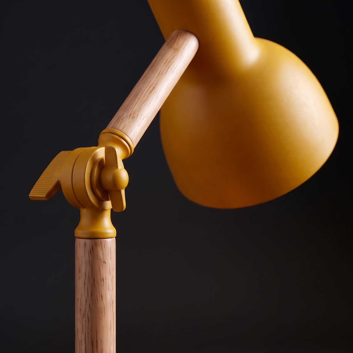 Close-up of the wooden arm and yellow shade of the desk lamp