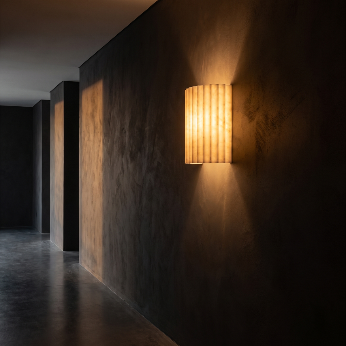 Fluted Resin Wall Sconce mounted in a dark hallway washing the wall with warm light
