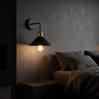Vintage Cone Wall Sconce mounted on a charcoal wall beside a bed in a dark bedroom