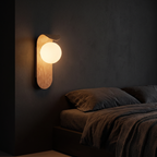 Oval Timber LED Wall Sconce shown to scale on the wall beside a bed