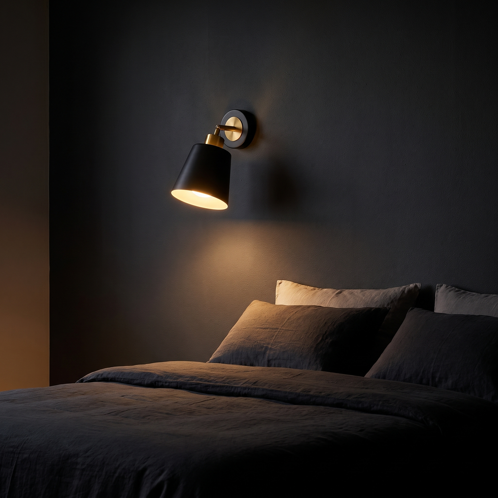 Swivel-Arm Cone Wall Sconce mounted on a charcoal wall beside a bed in a dark bedroom