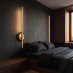Cordless Brass Bar Wall Sconce shown to scale on the wall beside a bed