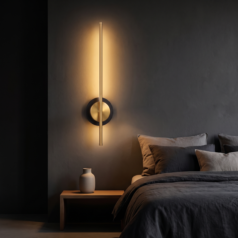 Cordless Brass Bar Wall Sconce mounted on a charcoal wall beside a bed in a dark bedroom