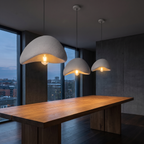 Wabi sabi stone-look pendant lights, a cluster of three sizes hanging at staggered heights over a long oak dining table