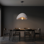 Wabi sabi stone-look pendant light shown to scale, hanging over a 4-seat dining table