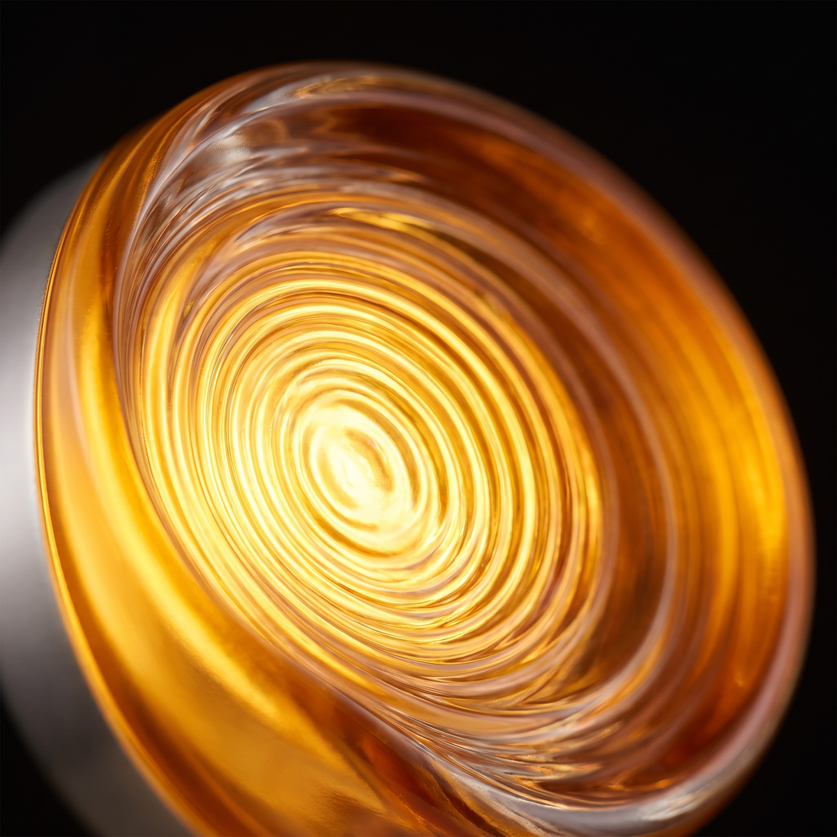 Close-up of the glowing ribbed amber acrylic disc