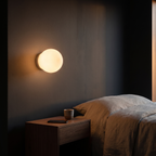 Floating milk glass globe wall sconce shown to scale, mounted beside a bed above a nightstand