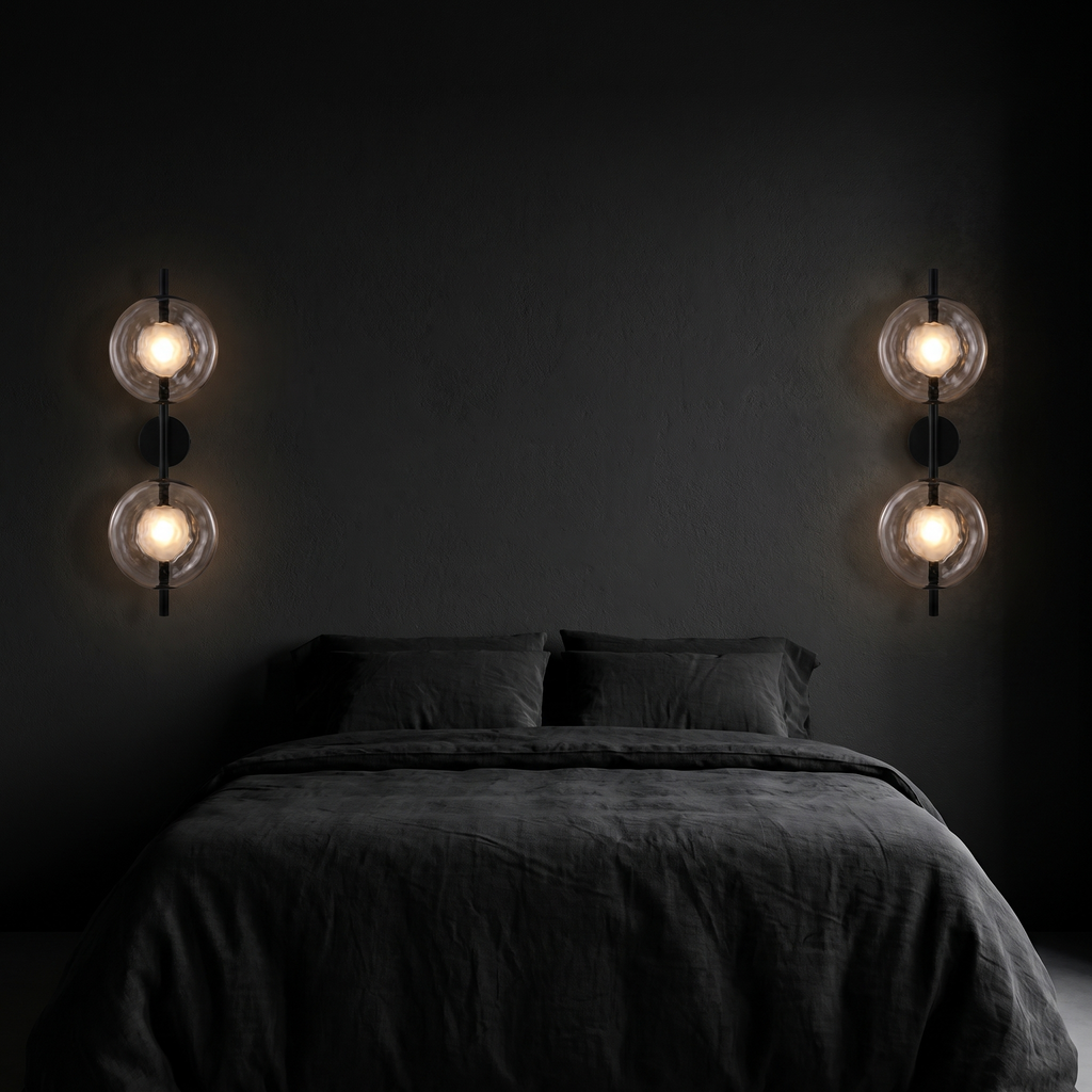 Double glass disc wall sconces, a pair mounted either side of a bed on a dark wall