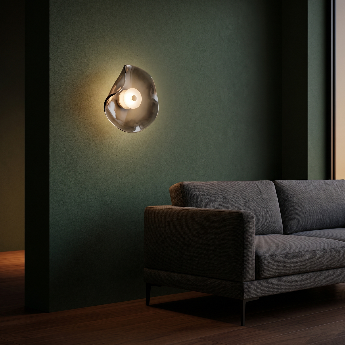 Wavy smoke gray glass wall sconce beside a sofa on a deep green wall