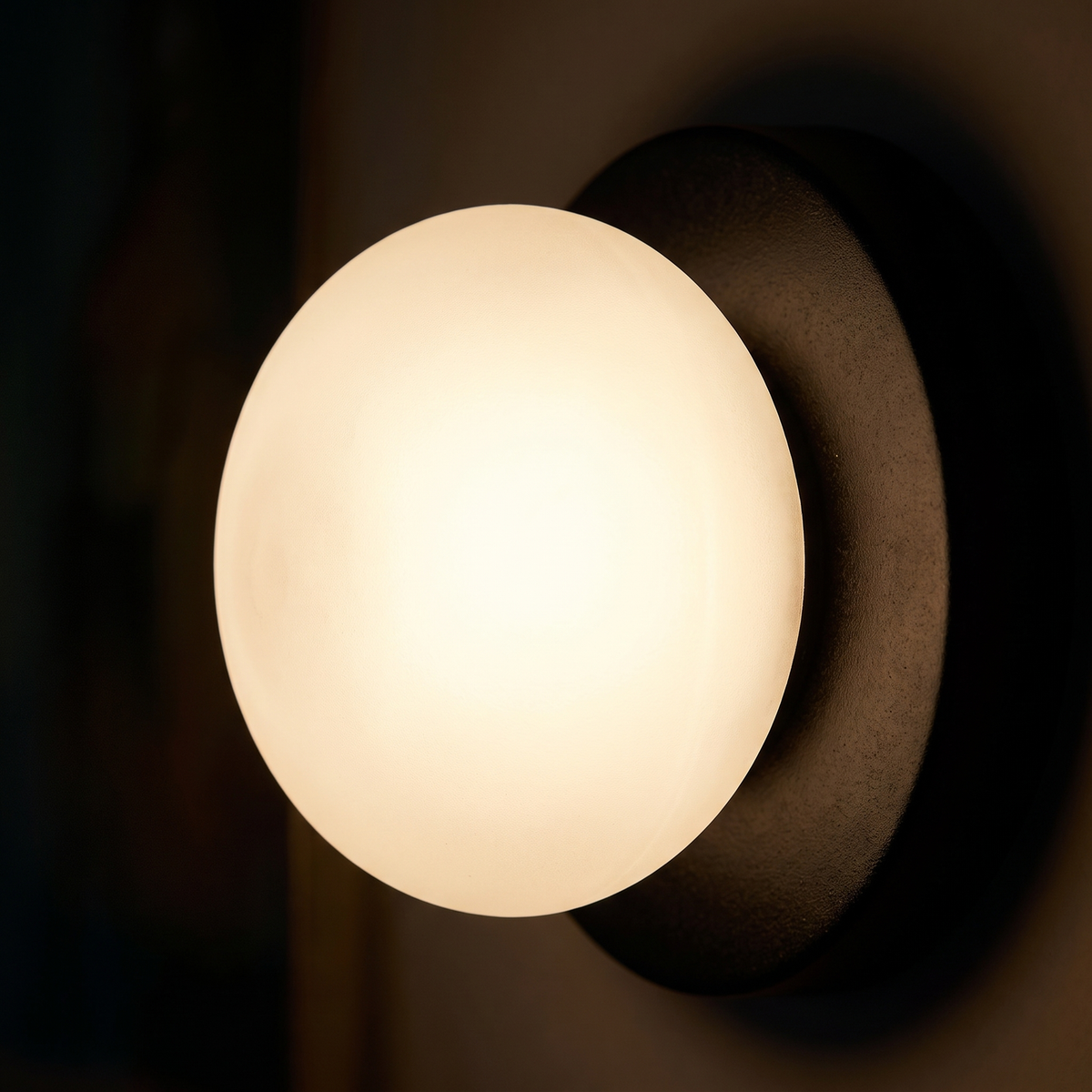 Close-up of the frosted glass globe glowing in front of the black disc