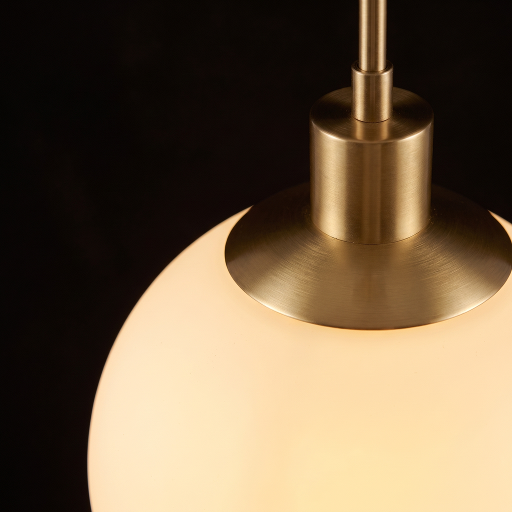 Close-up of the glowing opal glass globe and brushed brass collar