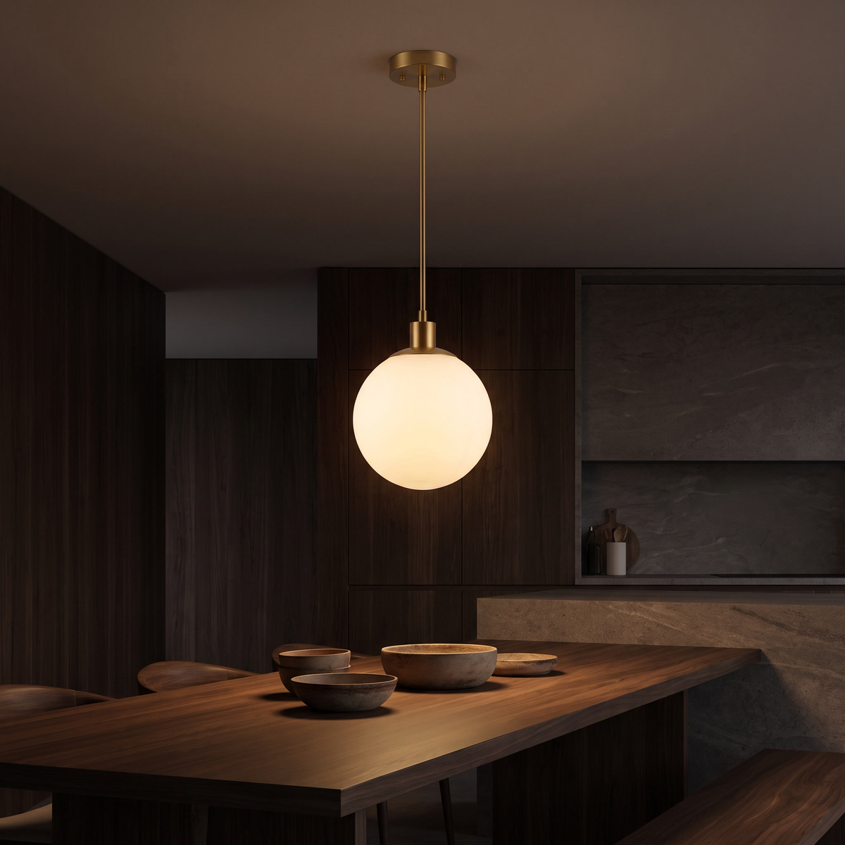 Milk glass globe pendant light hanging low over a dark walnut dining table set with ceramic bowls