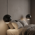 Black Mirror Globe Pendant Light beside a bed