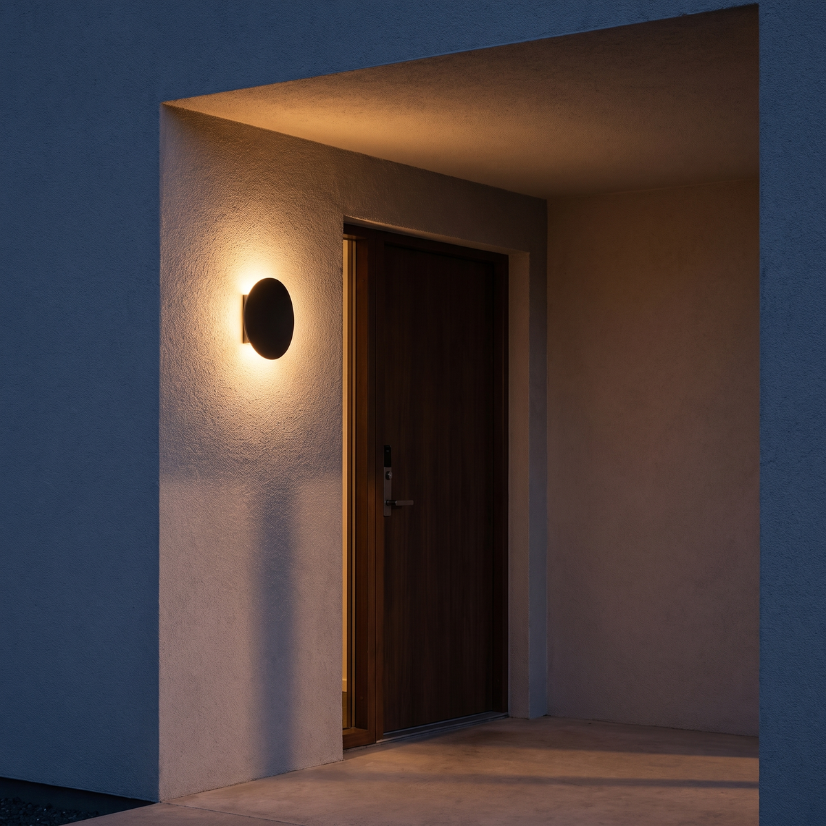 Black Pebble Wall Light beside a front door at dusk