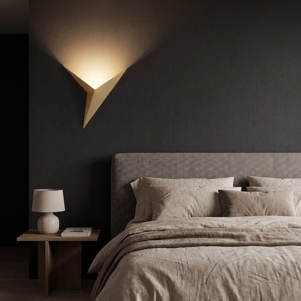 Gold Triangle LED Wall Sconce beside a bed at night