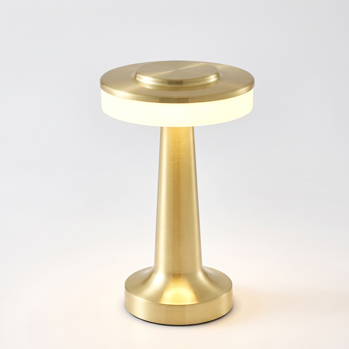 Gold cordless mushroom table lamp on white background