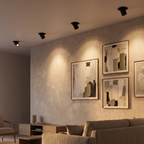 Black recessed spotlights washing light onto wall art
