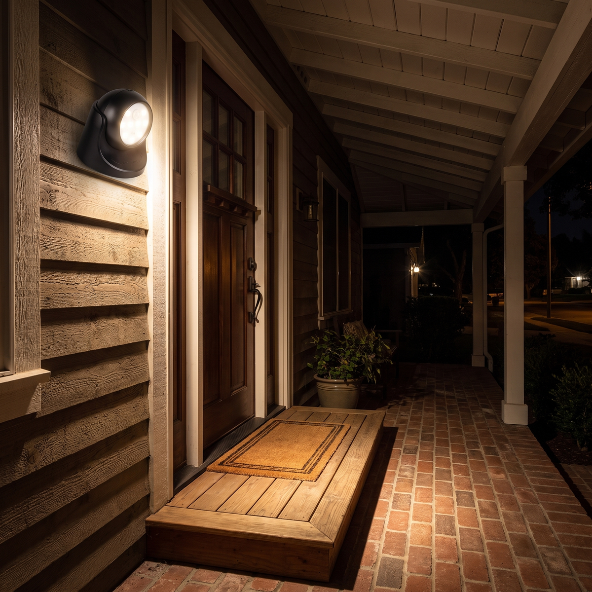 Black motion sensor light lighting a front porch at night