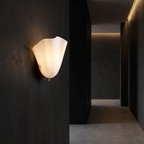 Fluted Glass Shell Wall Sconce in a dark modern hallway