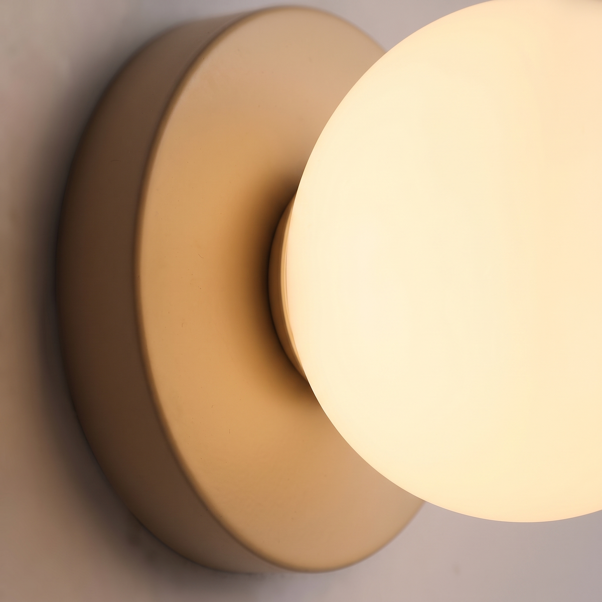 Macaron Globe Wall Sconce close-up of the glowing acrylic globe and base