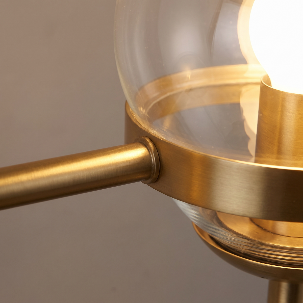Looped Cord Glass Globe Sconce close-up of the glass globe and gold arm