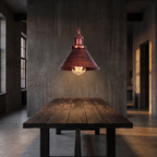 Rust copper cone pendant light over a loft dining table
