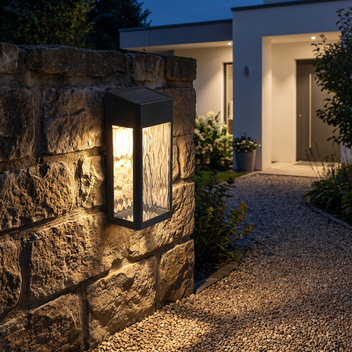 Solar wall lantern on a stone garden wall at night