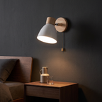 Nordic Wood Wall Sconce with Pull Chain above a bedside table