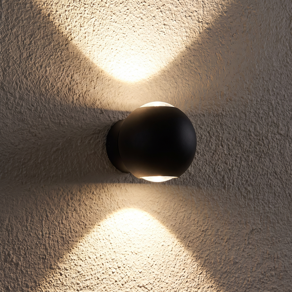 Close-up of the Modern Sphere Up Down Wall Light casting up and down beams on a textured wall