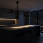 Modern Linear Spotlight Pendant Light over a dark stone kitchen island at night