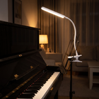 Modern Clip On Desk Lamp clipped to a music stand beside a piano