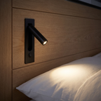 Modern Recessed Bedside Reading Light on an oak panelled wall beside a bed
