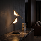 Modern Bird Table Lamp on a dark marble console in a living room at night