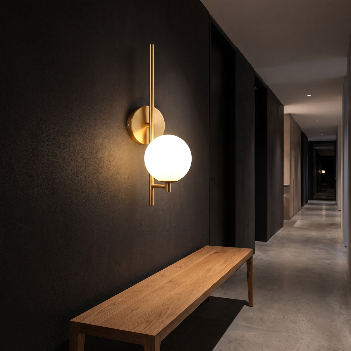 Modern Brass Globe Wall Sconce in a dark hallway above an oak bench