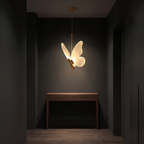 Modern Butterfly Pendant Light above a walnut console in a dark entrance hallway