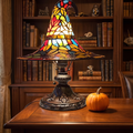 Stained Glass Witch Hat Lamp lit on a walnut desk in a study