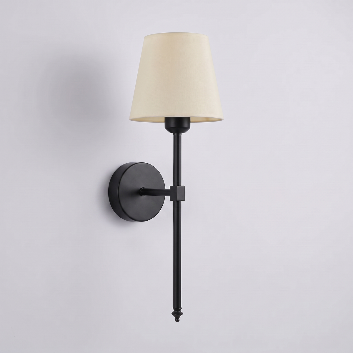 Cordless rechargeable wall sconce in matte black with a cream tapered fabric shade, on a plain grey studio background