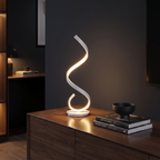 White spiral LED table lamp lit on a dark timber console against a charcoal wall
