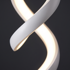 Close-up of the twisting white aluminium ribbon and continuous LED strip on the spiral table lamp