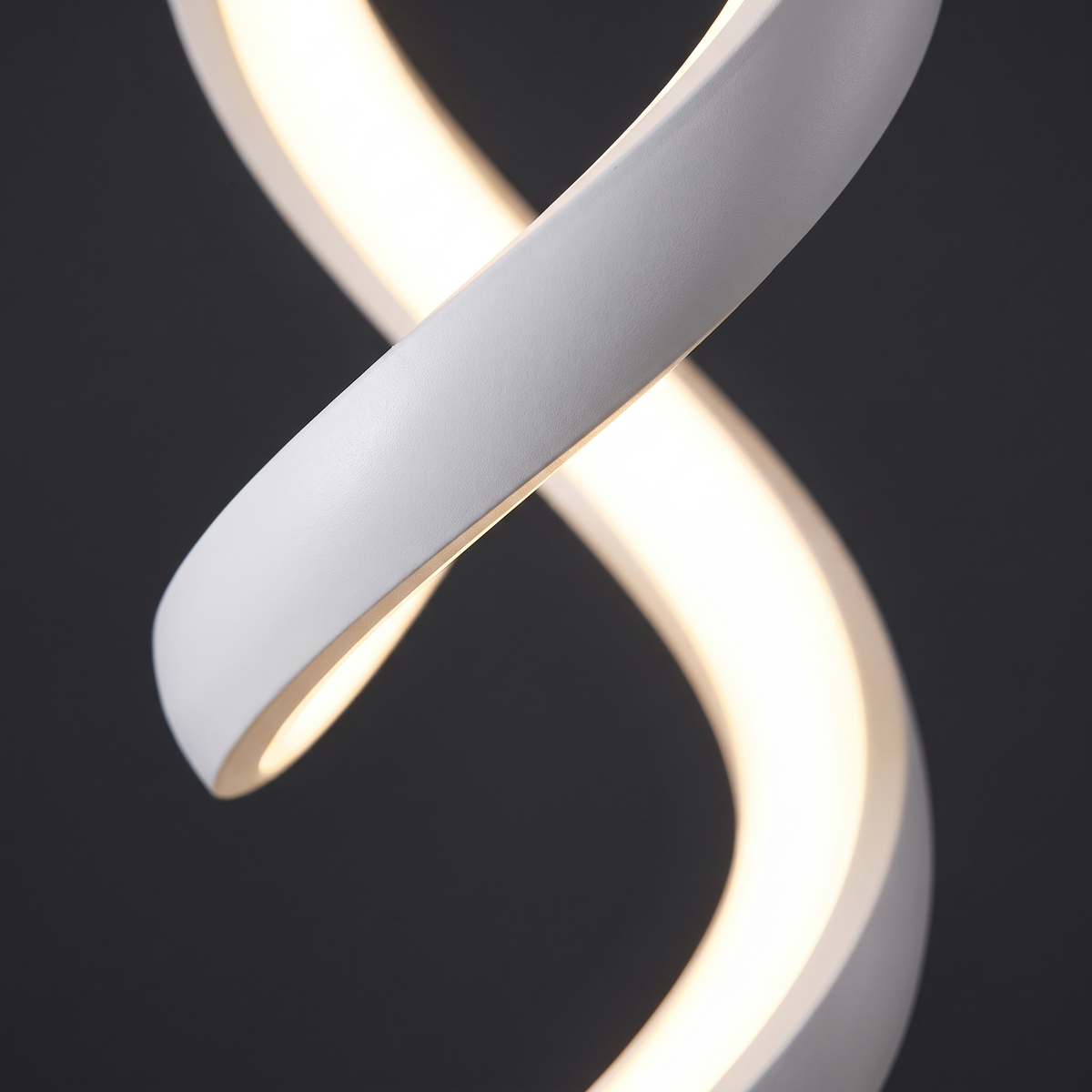 Close-up of the twisting white aluminium ribbon and continuous LED strip on the spiral table lamp